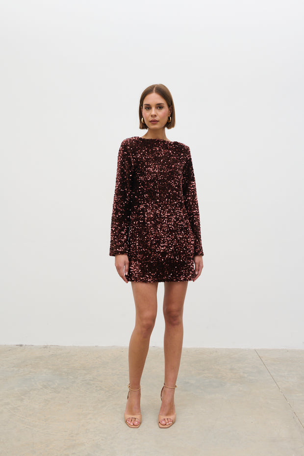 Woman wearing a sequin dress against a white background