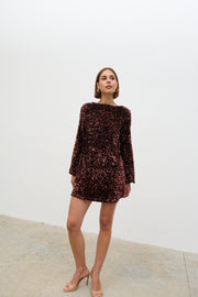 Woman wearing a dark sequin dress against a white background