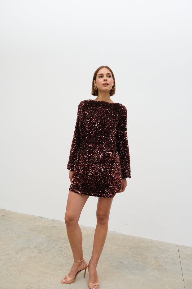Woman wearing a dark sequin dress against a white background