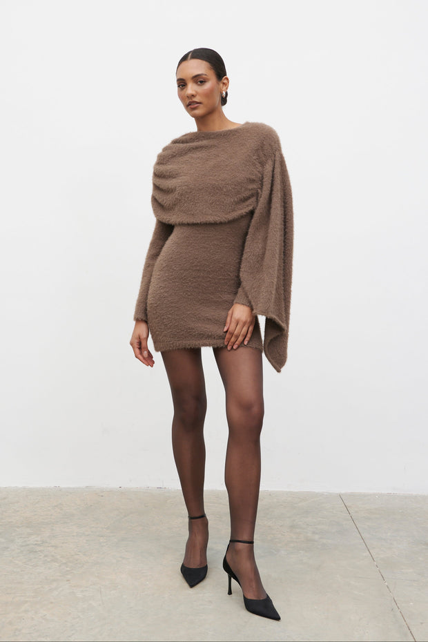 Woman wearing a brown knit dress against a white background