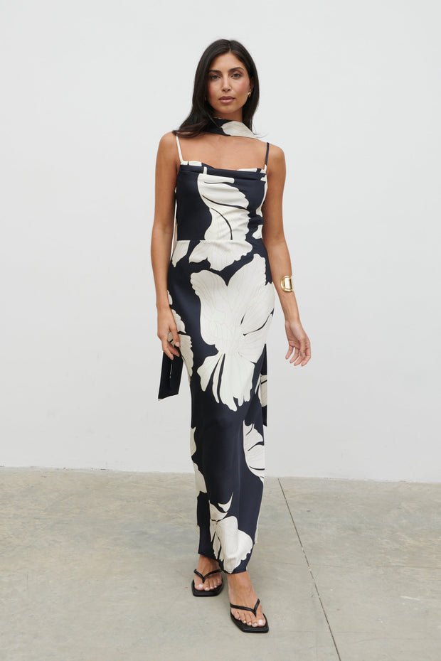 Woman wearing a black and white floral dress against a plain background