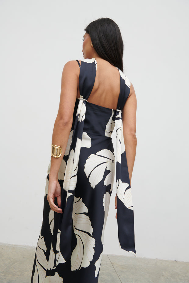 Woman wearing a black and white floral dress with a plain background