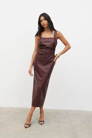 Woman wearing a brown satin dress against a white background