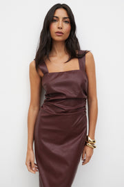 Woman wearing a brown dress against a white background