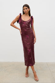 Woman wearing a burgundy sequin dress against a white background
