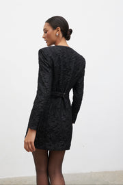 Woman wearing a black textured dress against a white background